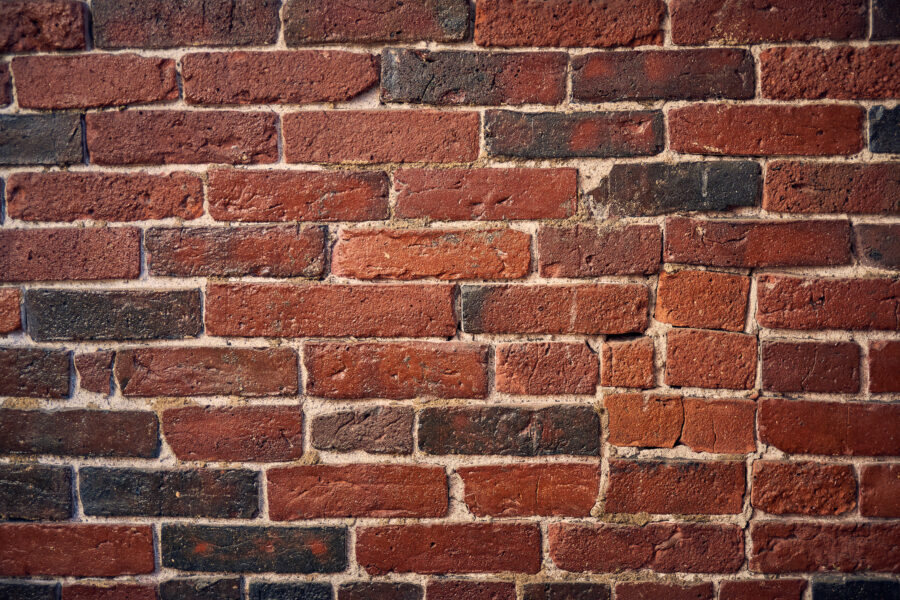 Close-up of a red brick wall, laid in a regular repeating pattern