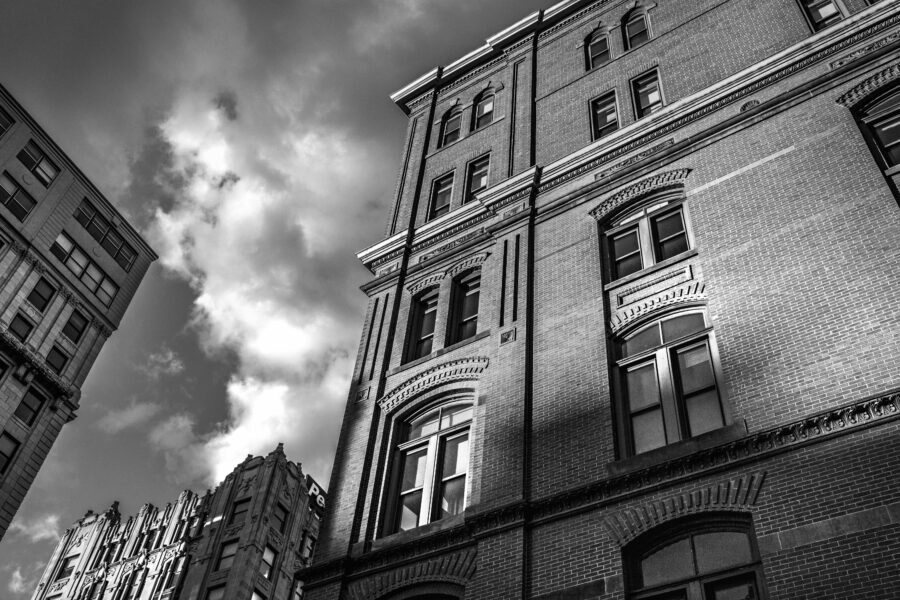 A dramatic black and white shot of an old building against a clouded sky
