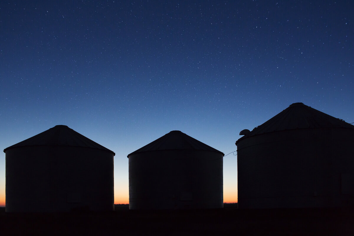 Farm buildings silhouetted against a dusk sky