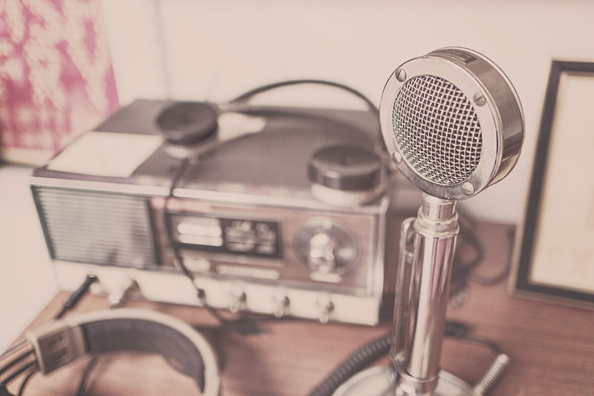 A vintage microphone beside an old radio set