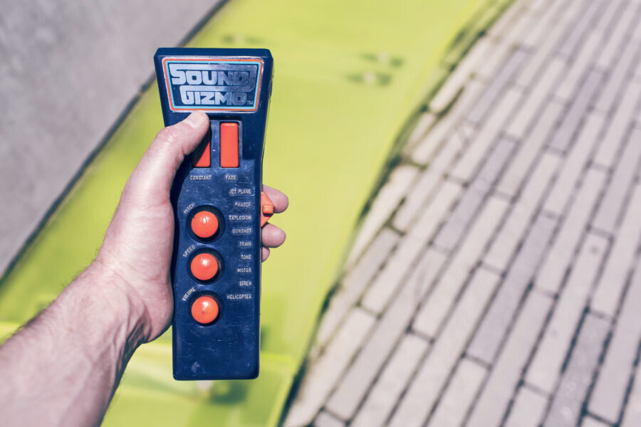 A hand holding a device labelled Sound
