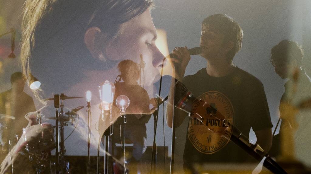 The band mid-set on the Montrose stage under a single hanging lamp