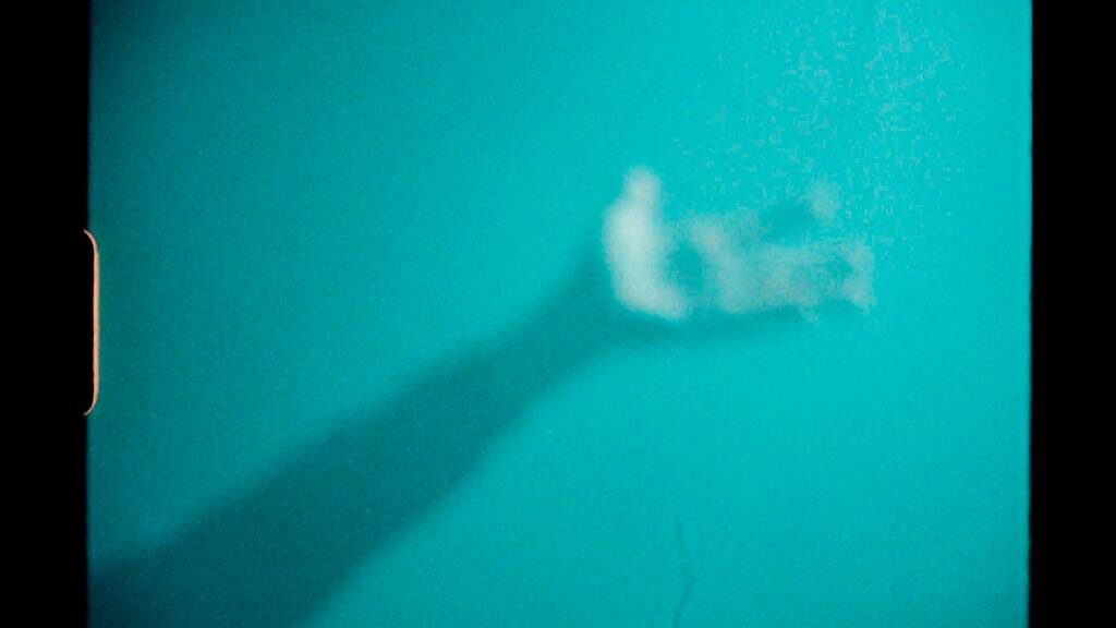 A teal-toned silhouette and shadow, an abstract frame from the self-initiated documentary Sold For Parts
